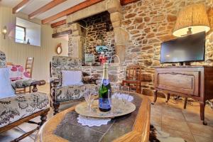 a living room with a table with a bottle of wine at Le paradis in Plouguenast