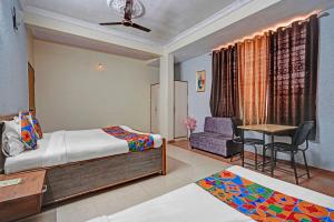 a bedroom with a bed and a desk and a chair at FabHotel Sandalwood Vibes in Bhopal