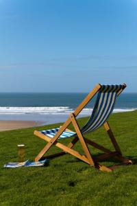 a beach chair sitting on the grass near the beach at Watersmeet Hotel in Woolacombe