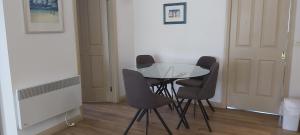 a dining room table with four chairs and a television at Margarets Lane in Warrnambool