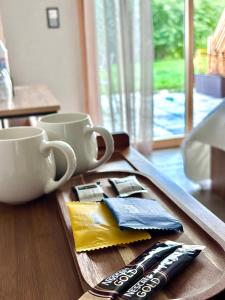 a wooden table with two cups and a tray with napkins at Lake View in Le Sentier
