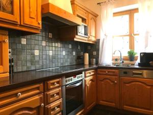 a kitchen with wooden cabinets and a stove top oven at Apartment SEEnsucht - Tolle Lage, nah am See, perfekt für Familien in Schliersee