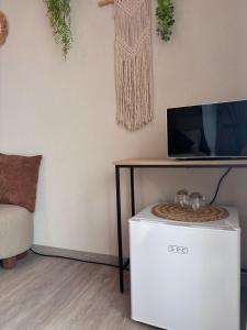 a living room with a tv and a table at Lake View in Le Sentier