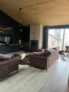 a living room with two couches and a table at A L OREE DU BOIS in Ferrières