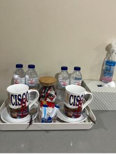 a tray with two cups and bottles of water at Baba Staytion 1-2-3 of SMDC Style Condo in Iloilo City +30 photos
