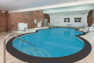 a large swimming pool in a room with a brick wall at Howard Johnson by Wyndham Mystic in Mystic