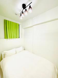 a bedroom with a white bed and a green window at The Grand Win in Fukuoka