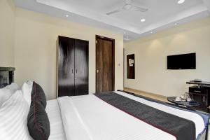 a bedroom with a large bed with a tv on the wall at Super Townhouse All In One in kolkata