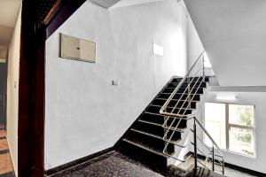 a staircase in a house with a white wall at Super Townhouse All In One in kolkata
