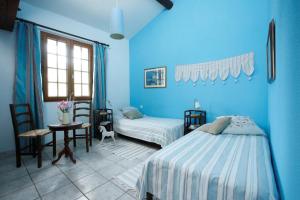 niebieska sypialnia z łóżkiem, stołem i krzesłami w obiekcie Château De Massignan w mieście Saint-Marcel