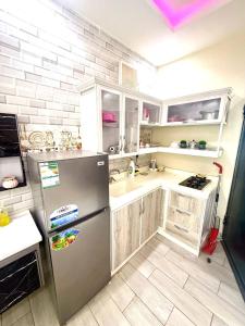 a kitchen with a stainless steel refrigerator and white cabinets at شاليهات سكون الغروب in Taif