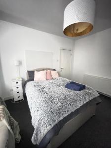 a bedroom with a large bed with pink pillows at Artsy Minimalist Suite in Southend-on-Sea