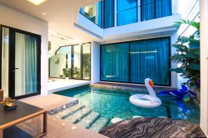 a swimming pool with a swan in a house at Indiluxe pool villa in Pattaya South