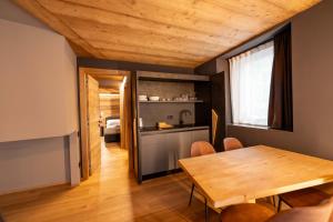 a kitchen and dining room with a wooden table at Le Suites de San Campel RTA in Ponte di Legno +56 photos