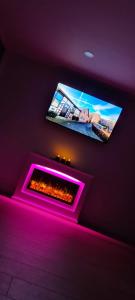 a room with a fireplace and a tv on the wall at Ferienwohnung Nideggen, Eifel, Nähe Ruhrsee, Nationalpark in Nideggen