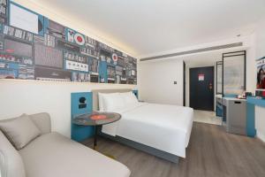 a hotel room with a white bed and a table at Ibis Dalian Development Zone Wanda Plaza in Jinzhou +9 photos