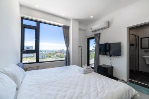 a bedroom with a large bed and a large window at IsShoNi B&B in Huxi