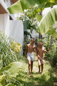 two young boys walking down a path in the grass at Emerald Villas by Paje Emerald Escapes Ltd in Paje
