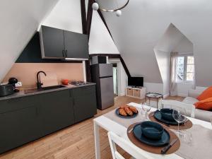 a kitchen and a living room with a table and chairs at Appartement rénové centre Pont-Audemer-calme, Wi-Fi, proche Honfleur in Pont-Audemer