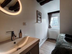a white bathroom with a sink and a window at Appartement rénové centre Pont-Audemer-calme, Wi-Fi, proche Honfleur in Pont-Audemer +6 photos