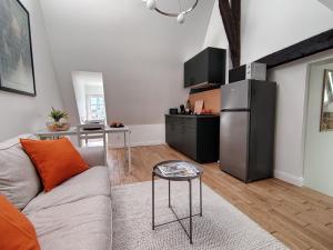 a living room with a couch and a refrigerator at Appartement rénové centre Pont-Audemer-calme, Wi-Fi, proche Honfleur in Pont-Audemer
