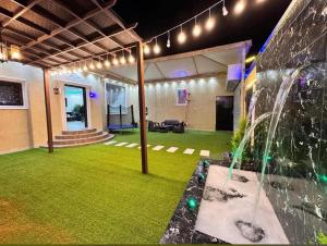 a living room with a green lawn and lights at شاليهات سكون الغروب in Taif