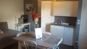a kitchen with a white table and a white refrigerator at Appartement Houlet in Tillé