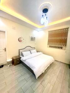 a bedroom with a large white bed and a chandelier at شاليهات سكون الغروب in Taif +8 photos