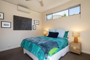 a bedroom with a large bed and a window at Blue Horizons at Ocean Grove in Ocean Grove