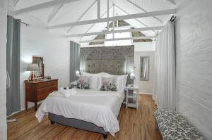 a bedroom with a large white bed and a desk at Hoekkraaltjie in Yzerfontein +40 photos