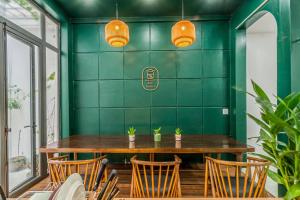 a green dining room with a wooden table and chairs at Laé Hostel in Tuy Hoa +67 photos