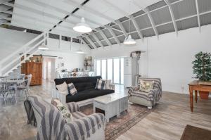 a living room with a couch and chairs and a table at Hoekkraaltjie in Yzerfontein