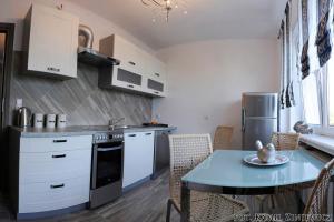 a kitchen with white cabinets and a table and a dining room at Gościniec w Malborku in Malbork
