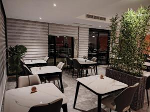 ein Restaurant mit weißen Tischen und Stühlen und Pflanzen in der Unterkunft Marigold Tripoli hotel فندق ماري قولد in Tripoli + 33 Fotos