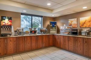 a restaurant with a counter with some food at Comfort Inn University in Amherst