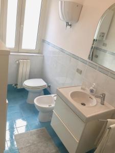 a white bathroom with a toilet and a sink at Vacanze a Gaeta in Gaeta