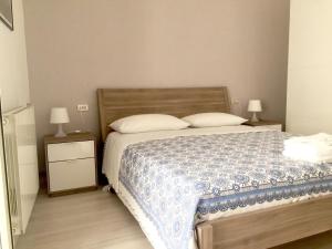 a bedroom with a bed and two night stands with lamps at Vacanze a Gaeta in Gaeta
