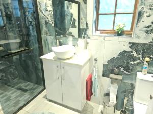 a bathroom with a white sink and a shower at Little Germany in Waterfall +22 photos