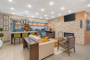 a living room with a kitchen and a fireplace at Country Inn & Suites by Radisson, Fairview Heights, IL in Fairview Heights