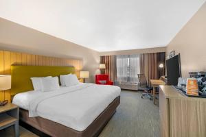 a hotel room with a large bed and a desk at Country Inn & Suites by Radisson, Fairview Heights, IL in Fairview Heights