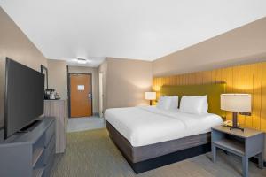 a hotel room with a bed and a flat screen tv at Country Inn & Suites by Radisson, Fairview Heights, IL in Fairview Heights +47 photos