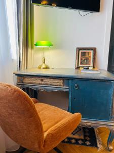 a desk with a green lamp and a chair at Art Boutique Residence - City Center - Calea Victoriei in Bucharest