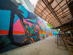 a wall covered in graffiti with a painting on it at Turtle Beach Resort in San Juan