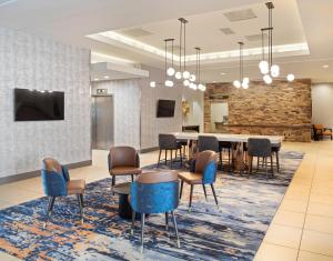 a lobby with chairs and a table and a tv at Radisson Hotel Salt Lake City Downtown in Salt Lake City