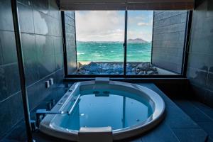 a bathroom with a tub with a view of the ocean at Sunset SPA Resort AJI by SETO CLAS in Takamatsu