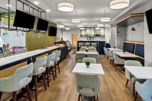 a restaurant with tables and chairs and a bar at Park Inn by Radisson, Kelowna in Kelowna