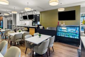 a restaurant with tables and chairs and a large aquarium at Park Inn by Radisson, Kelowna in Kelowna