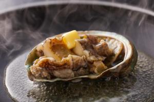 a oyster with meat and cheese on a plate at Shiraraso Grand Hotel in Shirahama
