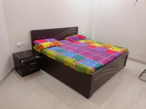 a bed with a colorful quilt on it in a room at sariska farmhouse villa in Alwar