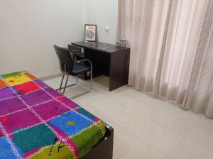 a bedroom with a desk and a bed and a chair at sariska farmhouse villa in Alwar +9 photos